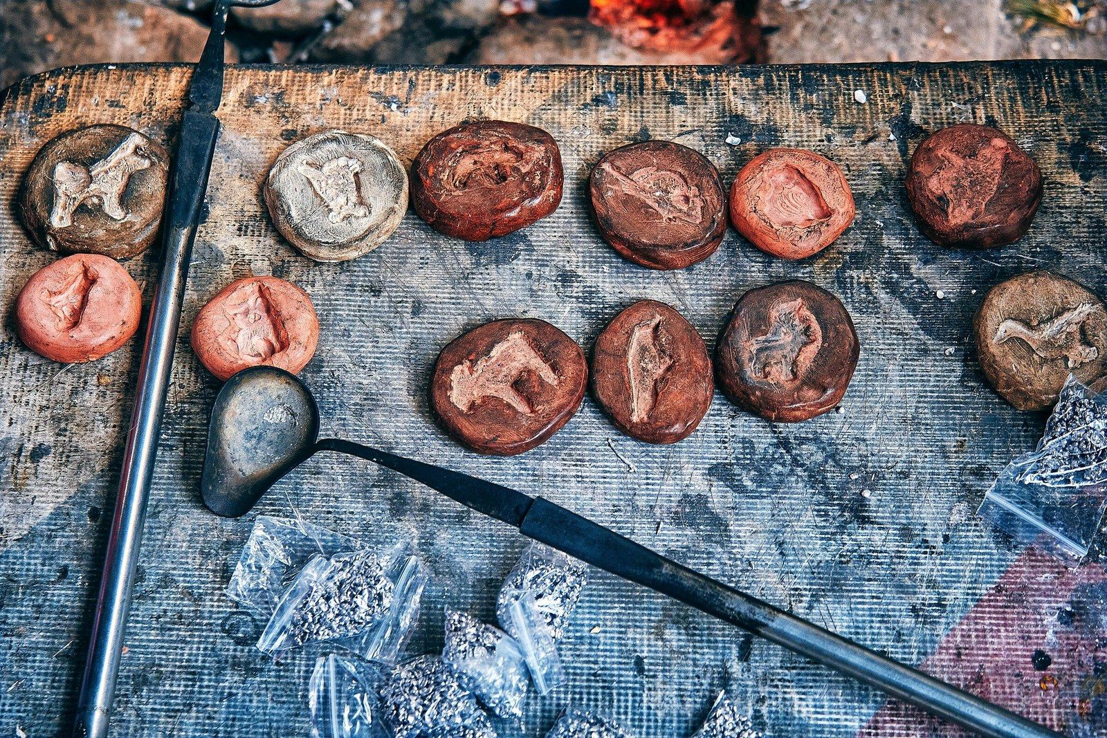 Handcrafted clay medallions with animal figures and sculpting tools on a workbench, symbolizing the process of shaping wholeness from imperfection