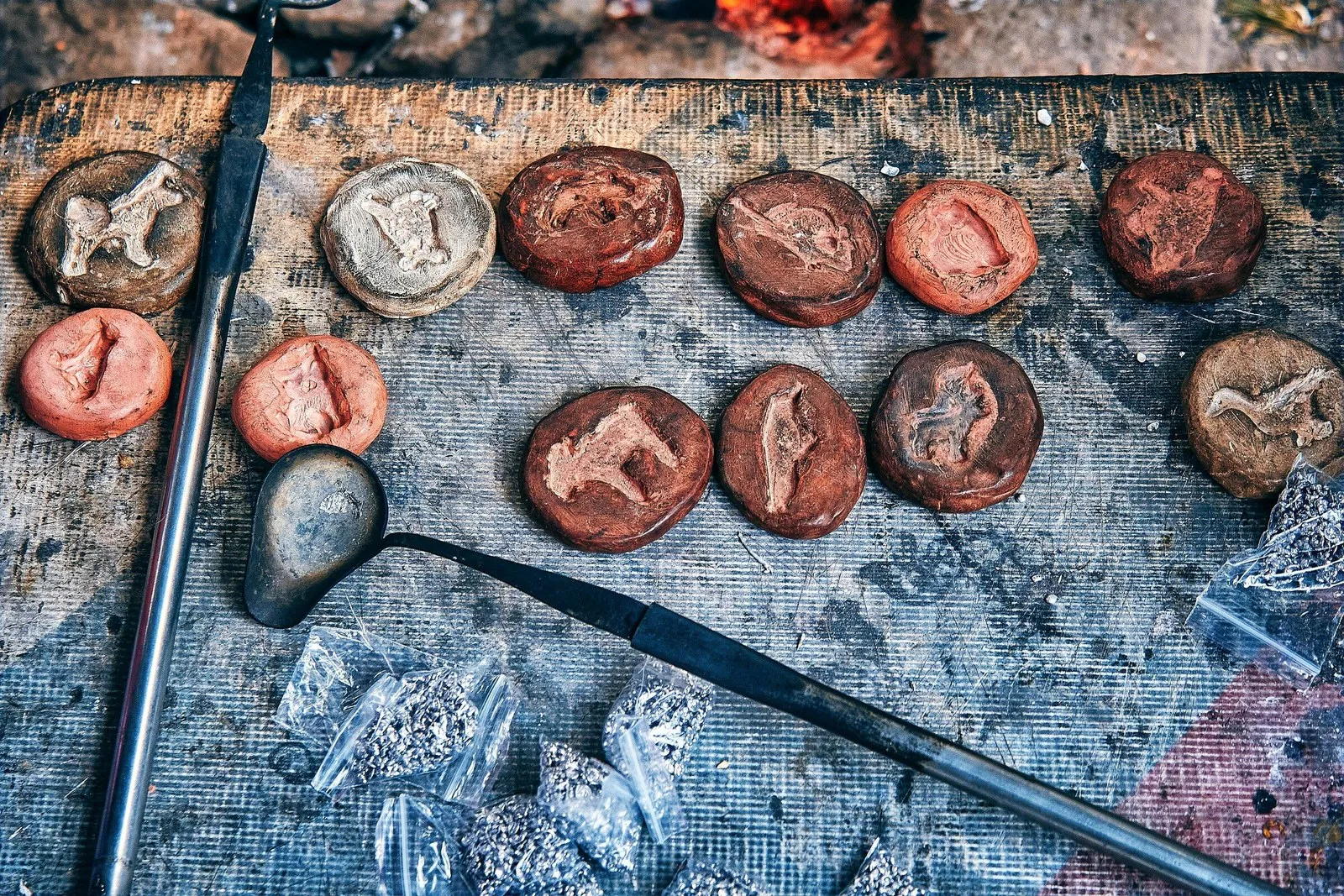 Handcrafted clay medallions with animal figures and sculpting tools on a workbench, symbolizing the process of shaping wholeness from imperfection